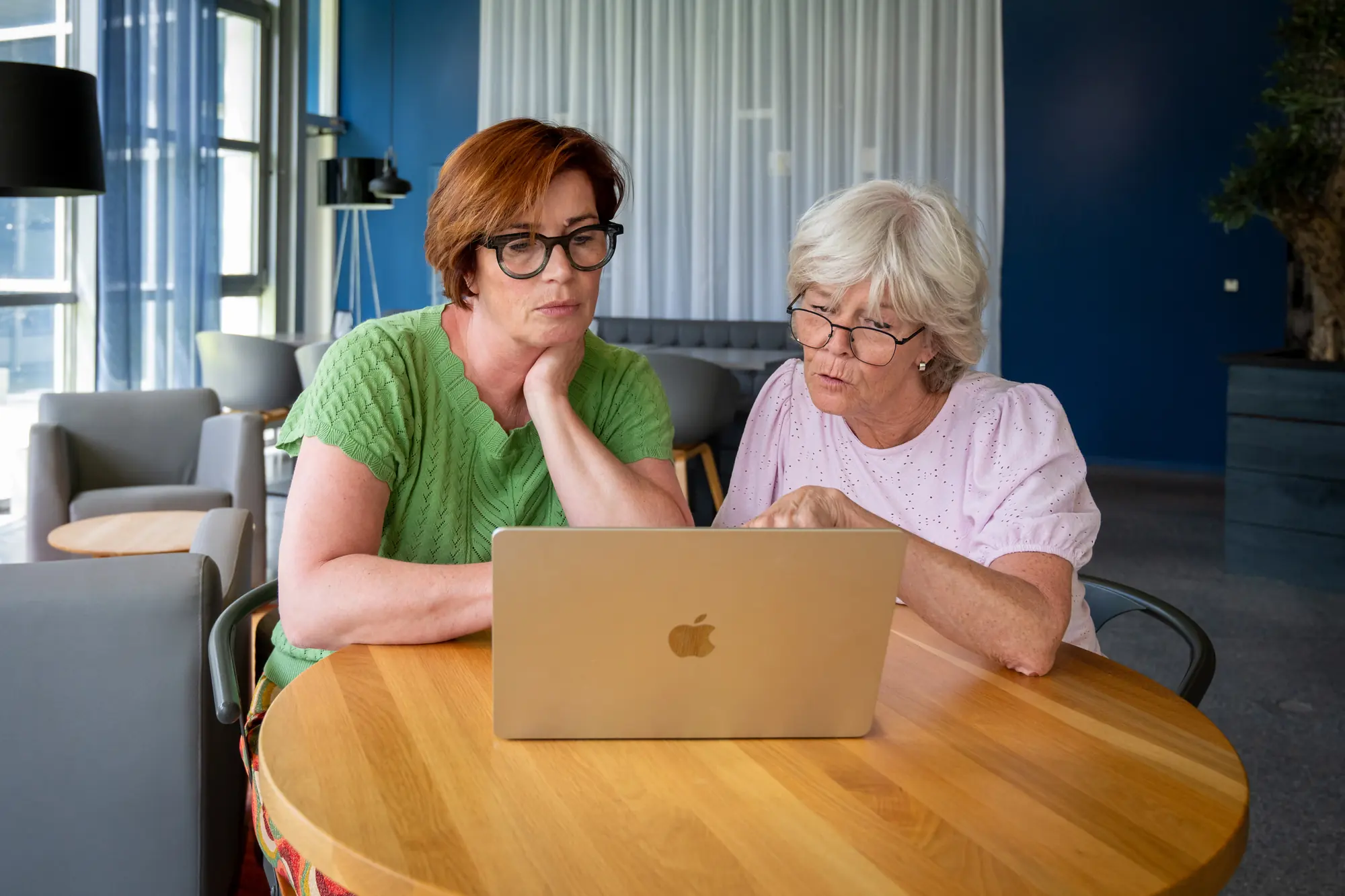 Twee vrouwen plannen samen aan tafel met laptop